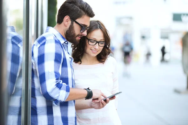 Smiling couple using smart phone — Φωτογραφία Αρχείου