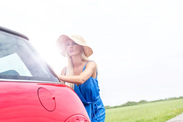 Kobieta, popychając samochód — Zdjęcie stockowe