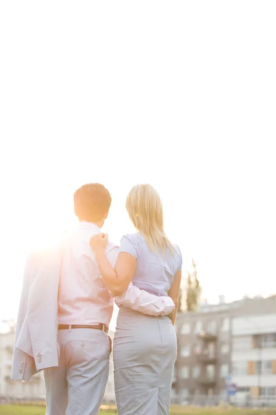 Pareja de negocios de pie con los brazos alrededor —  Fotos de Stock