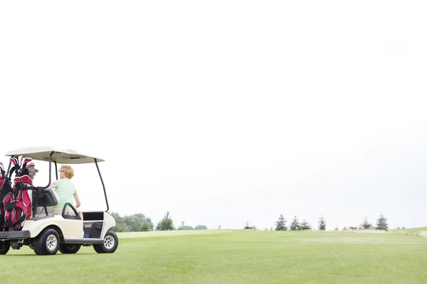 Couple sitting in golf cart — Stock Photo, Image