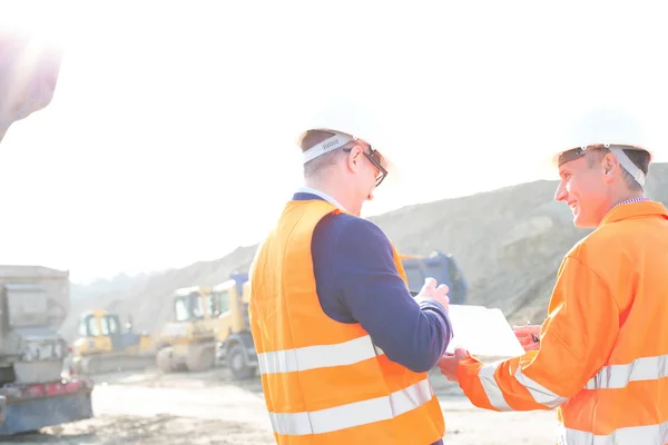 Ingenieros discutiendo sobre portapapeles —  Fotos de Stock