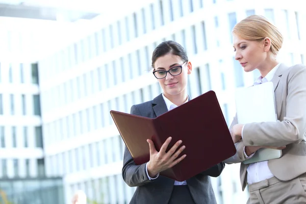 Geschäftsfrauen lesen Ordner — Stockfoto