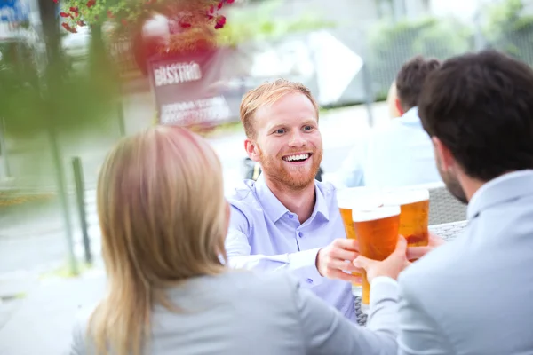 Geschäftsmann stößt mit Bierglas an — Stockfoto