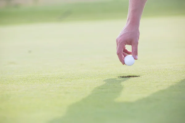 Mão segurando bola de golfe — Fotografia de Stock