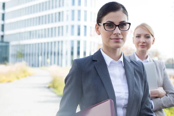 Businesswoman with colleague standing — Stockfoto