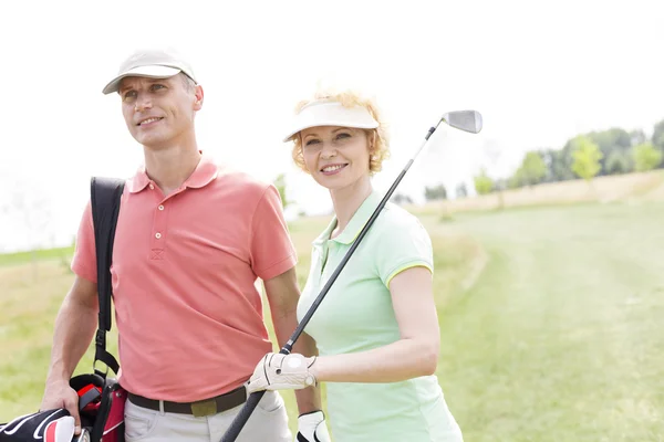 Female friends standing at golf course — Stok fotoğraf