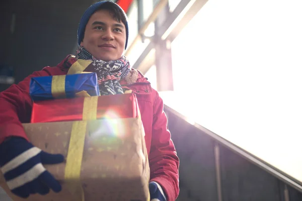 Smiling man holding gifts — Stock Photo, Image