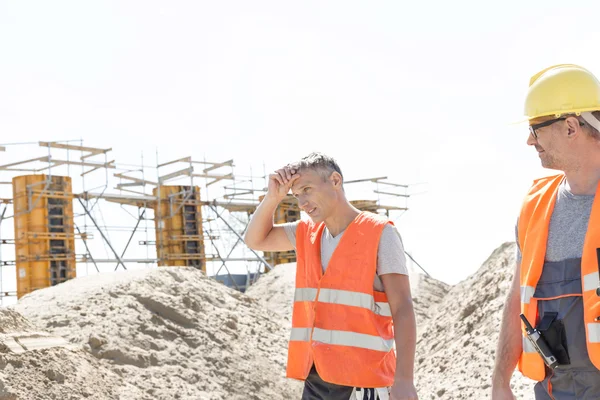 Worker looking at tired colleague — Stockfoto