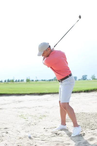 Man swinging at golf course — Stockfoto