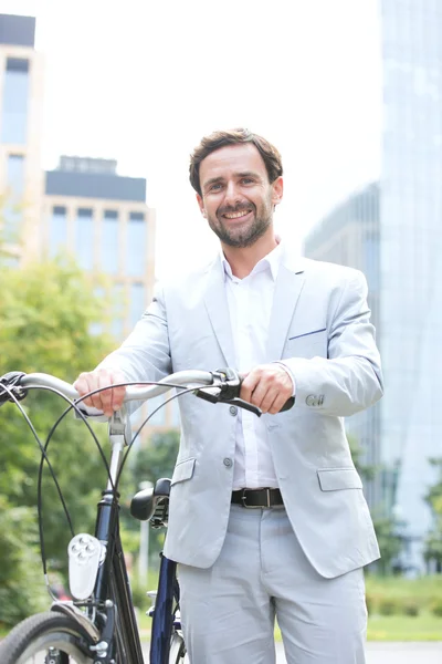 Homem de negócios feliz segurando bicicleta — Fotografia de Stock