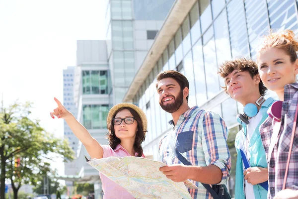 Woman pointing away in city Stockbild