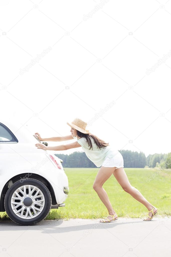 woman pushing broken down car