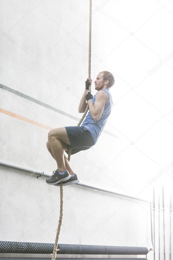 determined man climbing rope