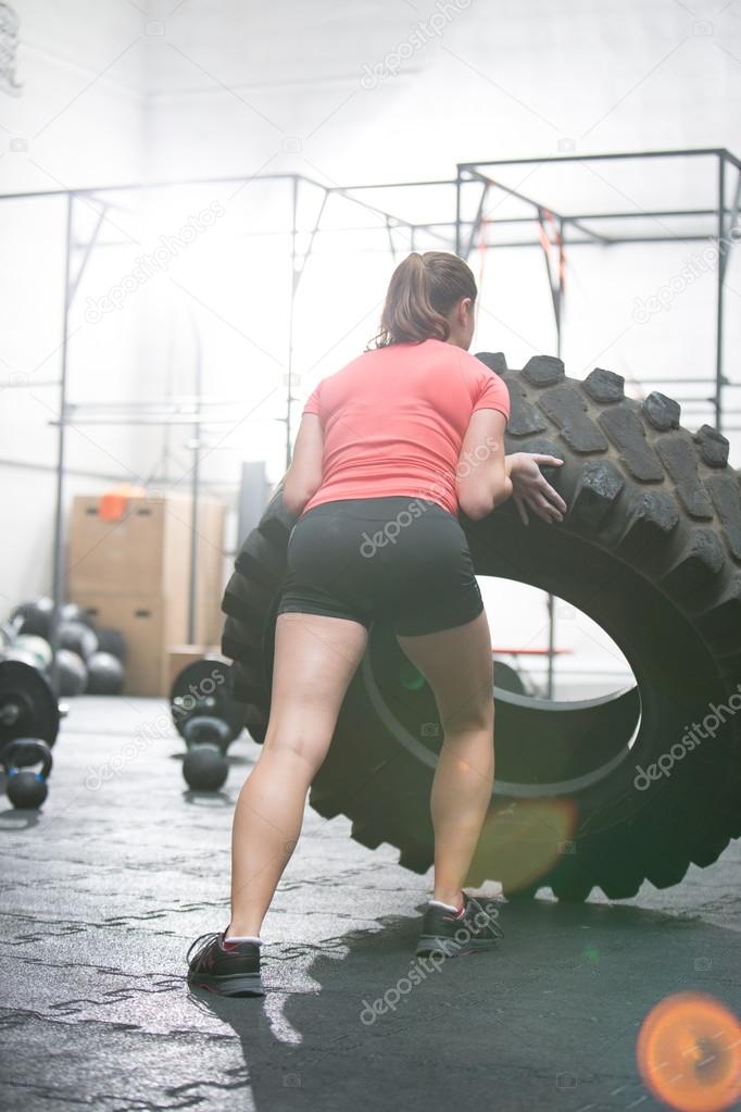 woman flipping tire in gym