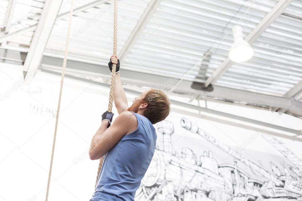 dedicated man climbing rope