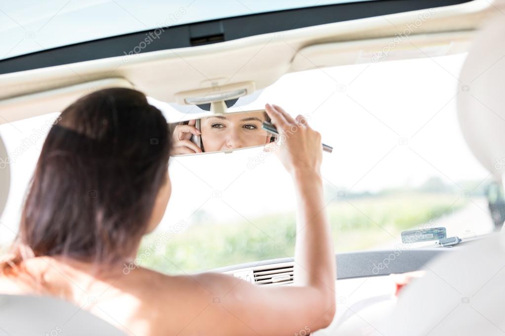 Woman adjusting rearview mirror