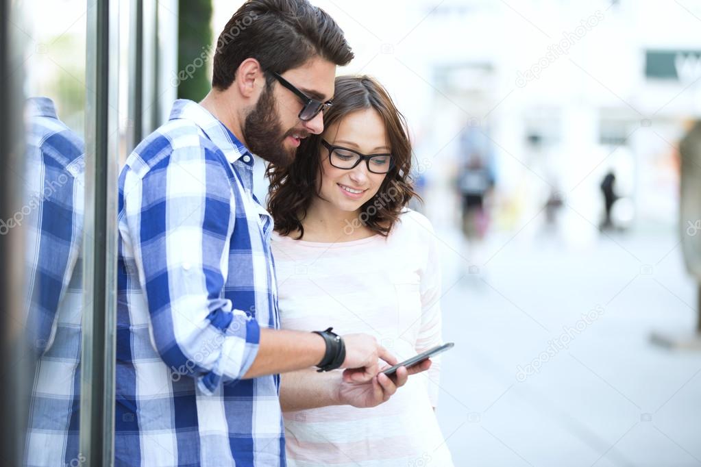 Smiling couple using smart phone