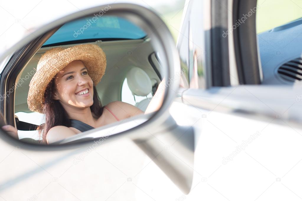 Reflection of woman in rearview mirror