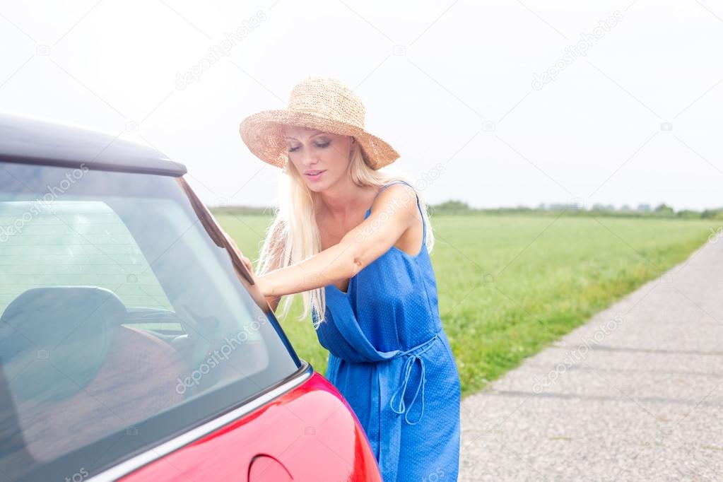 Woman pushing broken down car