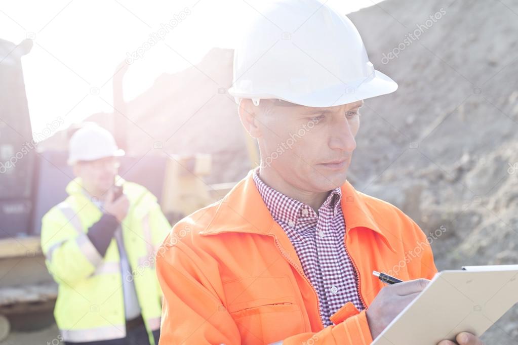 Engineer writing on clipboard