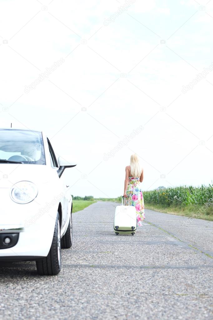 woman leaving broken down car