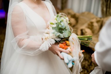 Gelin zarif elleriyle güzel düğün buketini tutuyor.