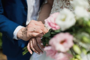 Gelin zarif elleriyle güzel düğün buketini tutuyor.