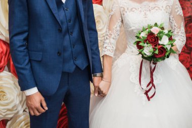 Gelin zarif elleriyle güzel düğün buketini tutuyor.