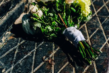 Gelinin güzel bir buketi alyansların yanında yatıyor.