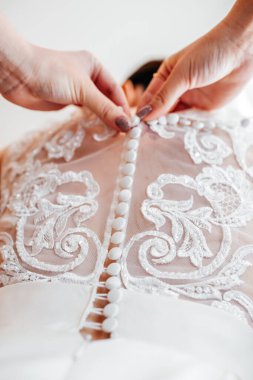 Gelin beyaz elbisesinde bir korseyle bağlandı.