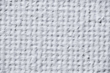 Macro image of white paper surface showing a soft embossed grid pattern.