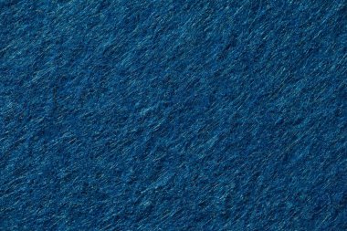 Close-up of deep blue felt fabric showing fine fibrous texture and soft surface, perfect for design, craft, or textile backgrounds.