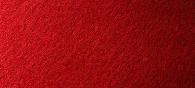 Yumuşak lifleri ve bulanık yüzey dokusunu gösteren kırmızı keçeli kumaşın makro görüntüsü.