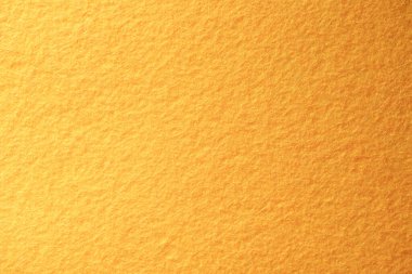 Turuncu keçeli kumaşın makro görüntüsü, el sanatları, tekstil ve sıcak tasarım arka planları için ideal bulanık bir yüzey dokusu içerir..
