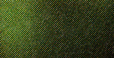 Üst üste binen cyan, sarı ve siyah yarım tonlu noktaların yakın plan görüntüsü lifli kağıt üzerinde koyu yeşil bir doku oluşturuyor..