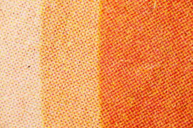 Dikey sarı ve morumsu yarım ton noktalı dokulu kağıt makro yüzeyde solgunluktan yoğun turuncu-kırmızı tonlara kayıyor..
