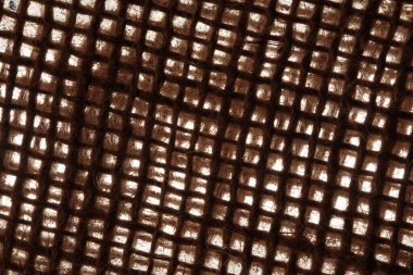 Arkadan aydınlatılmış kaba bir çuval bezi dokunun makro görüntüsü. Kalın, iç içe geçmiş lifler ve açık ızgara deseni güçlü bir kontrast ile sıcak, organik bir doku oluşturur..