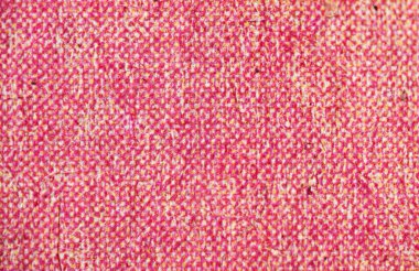 Yoğun pembe ve sarı yarım tonda basılmış fibröz kağıdın aşırı yakın çekimi görünür lifler ve zayıf çiziklerle canlı benekli bir doku oluşturur..