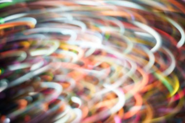 Çok renkli parlak girdaplar kıvrımlı, üst üste binen çizgiler ve arka planda hafif hareket bulanıklığı. Teknoloji, müzik, gece hayatı ve modern tasarım için enerjik soyut arkaplan.