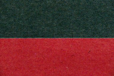 Üzerinde koyu yeşil yarım tonlu nokta alanı olan baskılı kağıdın makro yakın plan görüntüsü ve altında keskin yatay kenarlı koyu kırmızı bir mürekkep alanı var. Tasarım için kalın retro yazdırma dokusu.