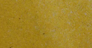 Görünür lifler ve küçük lekelerle sıcak hardal sarısı el yapımı kağıt dokusu içeren stop-motion video. Zanaat, tasarım ve klasik projeler için soyut eko-tarz arkaplan.