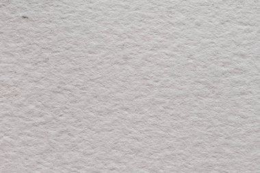 Görünür doğal tahıllı ve desenli yüzeyi olan kaba beyaz suluboya kağıtlarının yakın çekimi, resim, kırtasiye, modelleme ve tasarım projeleri için ideal bir sanatsal zemin..