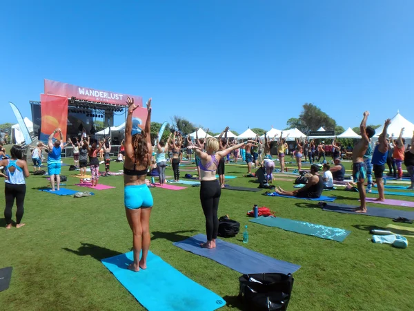 People raise arms over head during outdoor yoga class — Stock Photo, Image