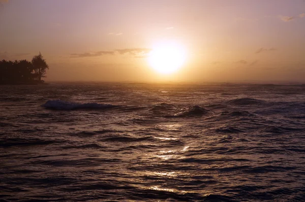 Puesta de sol sobre el océano con olas moviéndose a la orilla — Foto de Stock