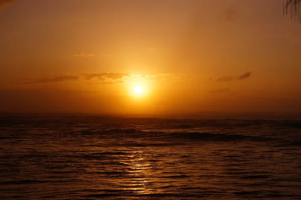 Pôr do sol sobre o oceano com ondas se movendo para a costa — Fotografia de Stock