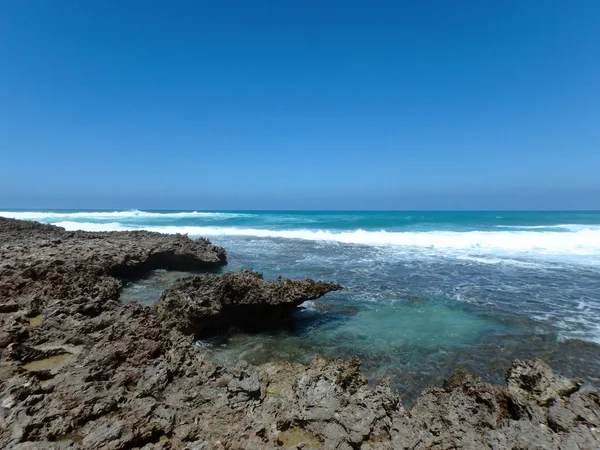 Zerklüftete Korallenfelsen mit brechenden Wellen — Stockfoto
