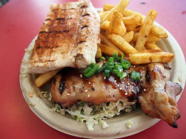 Barbekü tavuk ve Ono ile lahana salatası ve patates kızartması bir kağıt üzerinde pl