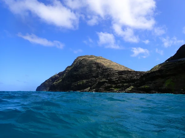 Onde dell'oceano ondulano con il faro di Makapuu e puntano nel dist — Foto Stock