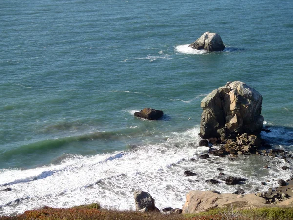 Waves roll toward large rocks and shore — Stock Photo, Image