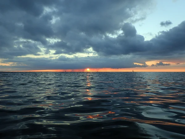 Sonne versinkt unter Wolken, während sie sich in den Pazifik senkt — Stockfoto